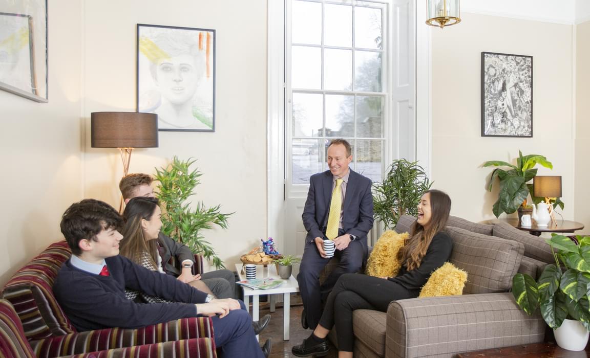 Head of College in the Sitting Room with students