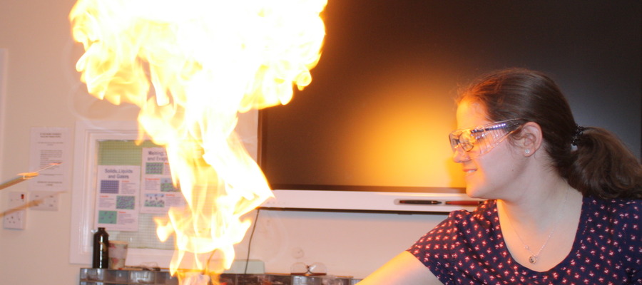 Head of Science, Caroline Thorne, is holding methane bubbles which have been lit.